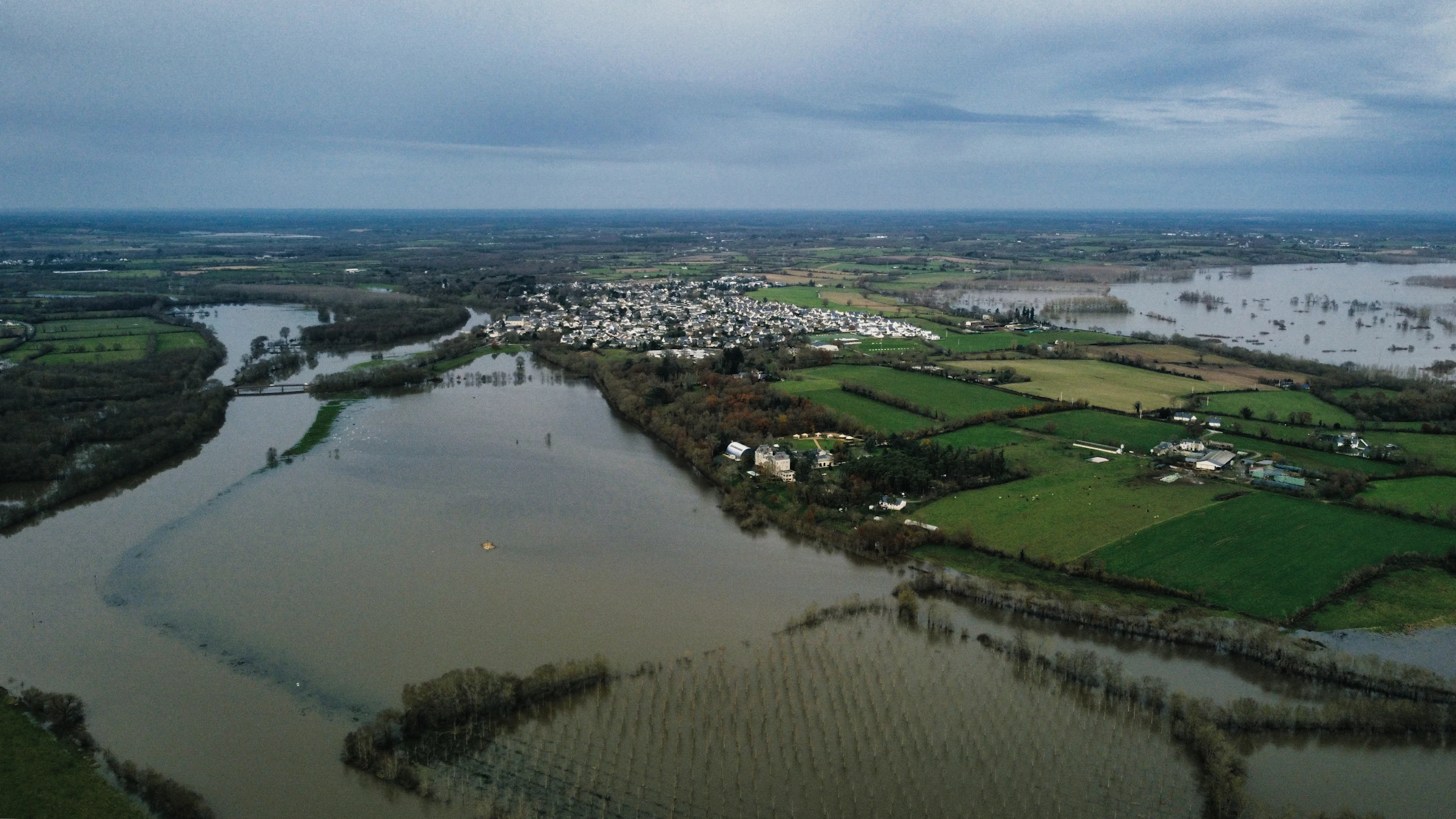 Flooded farmland and a town, seen from the air.